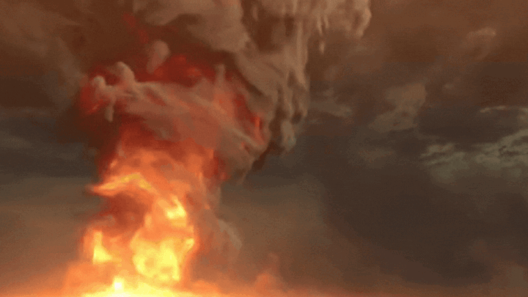 A large explosion with thick smoke and fire rising into the sky against a dark, ominous cloud-filled background.