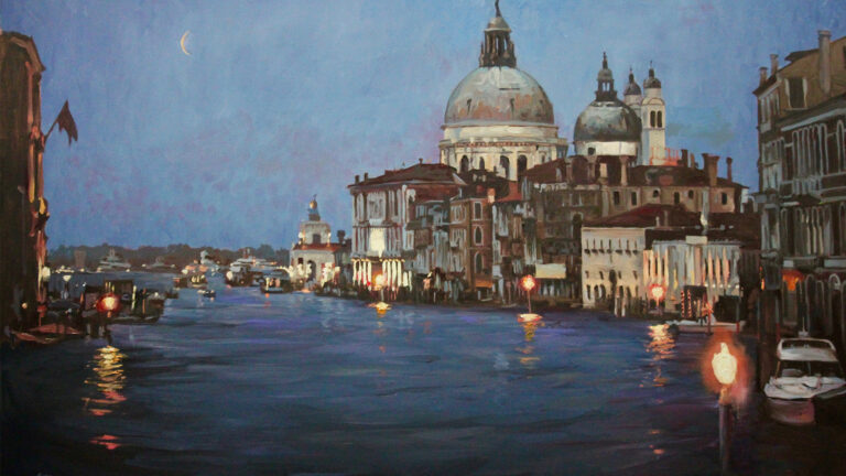 View of a city canal at dusk with illuminated buildings and domed church in the background.