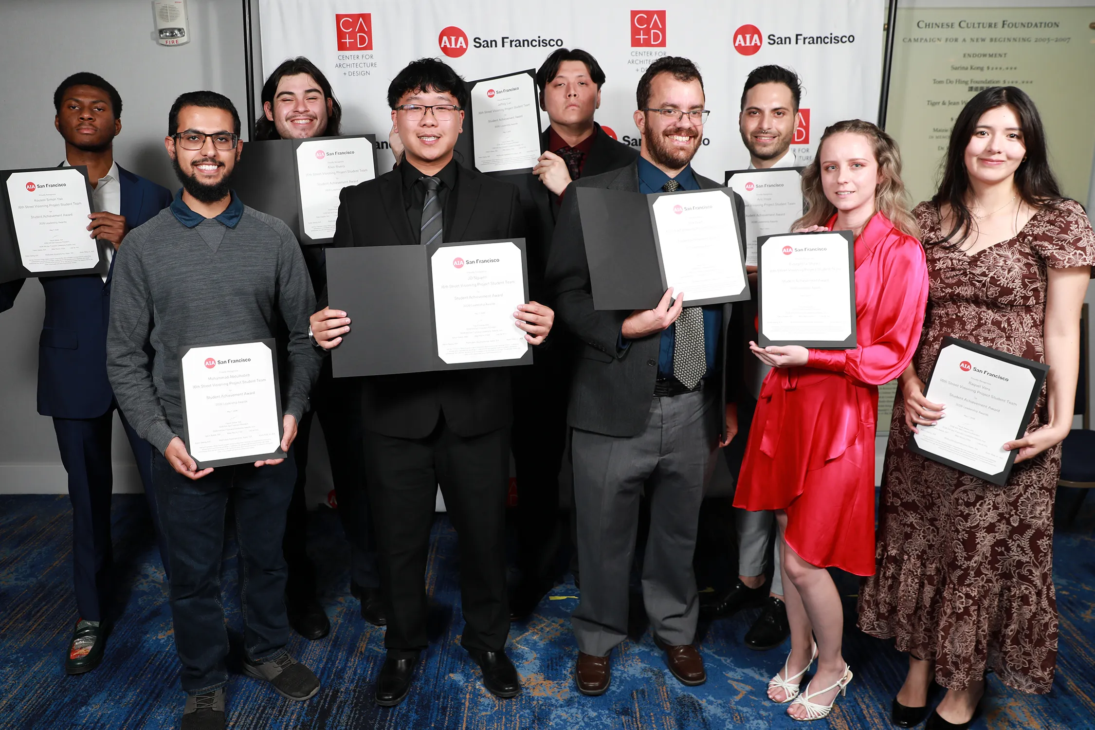 Group of students holding awards at a graduation ceremony.