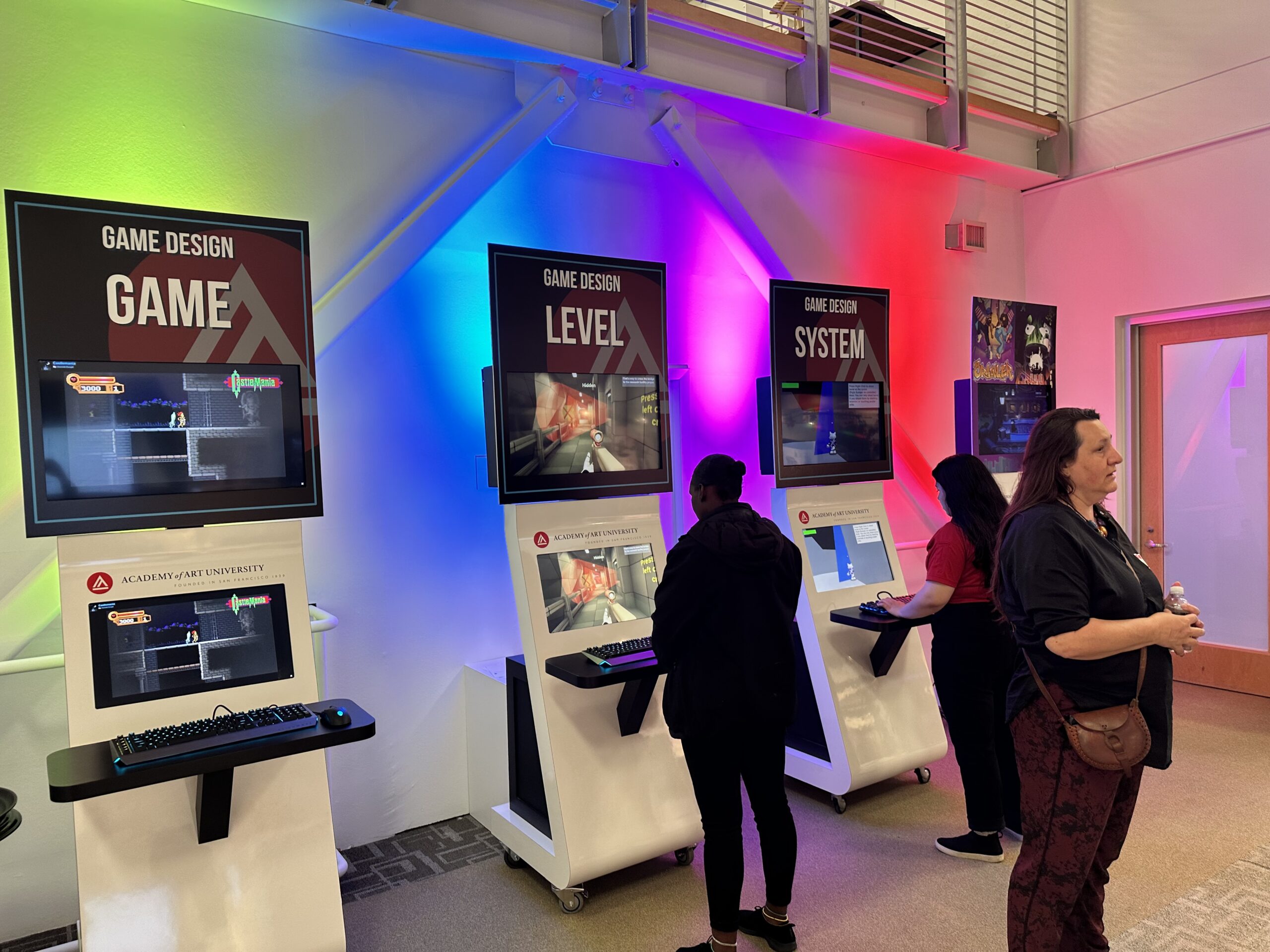 People playing video games on arcade machines labeled 