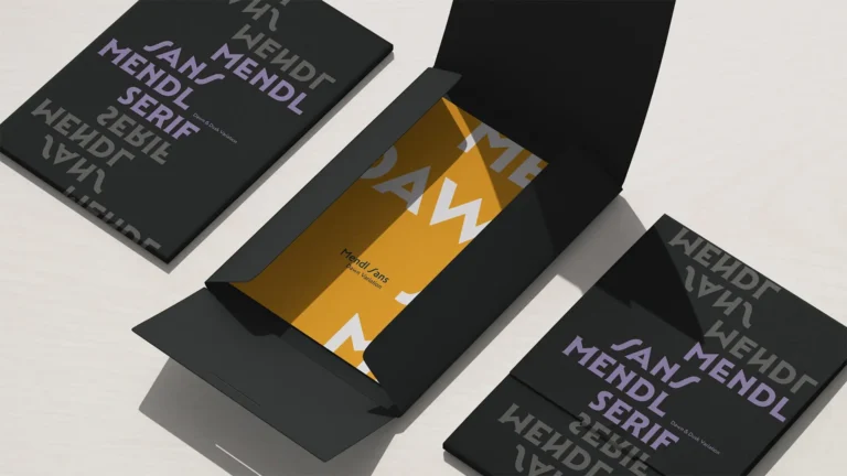Open black folders and a yellow booklet with large white letters and name Mendl Jans on a light surface.