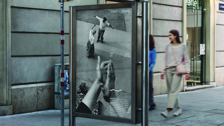 People walk past a sidewalk advertisement display on a city street.