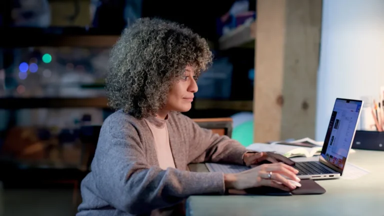 Online Learning student, woman sitting at a desk using a laptop.