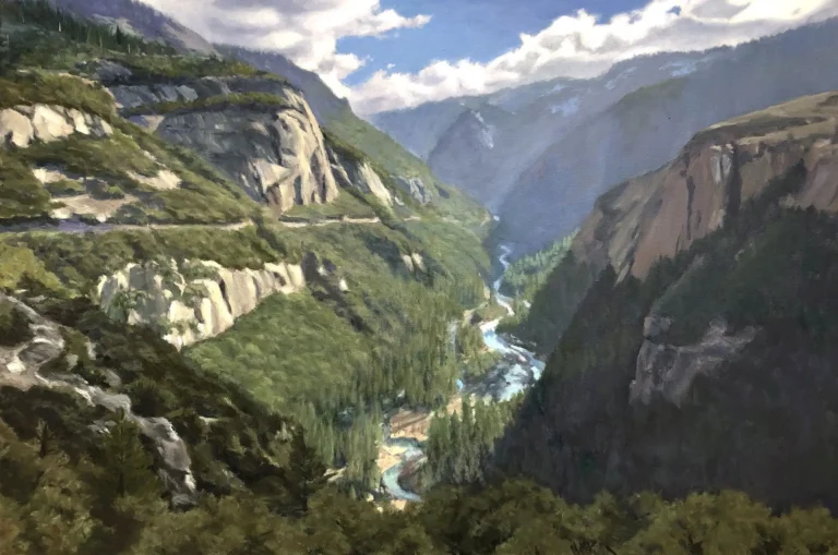 Mountain valley with steep cliffs, forest, and winding river.