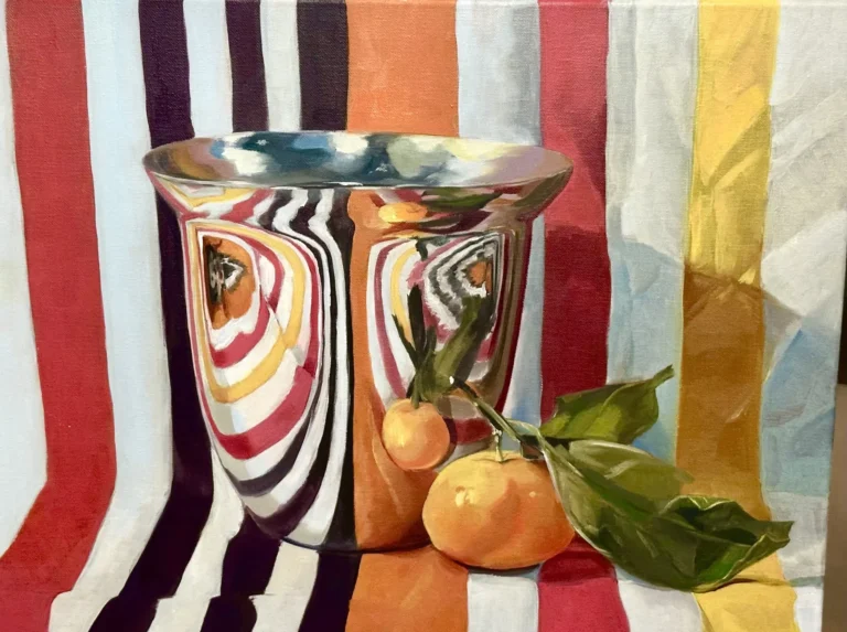 Colorful striped background with a ceramic cup and oranges nearby
