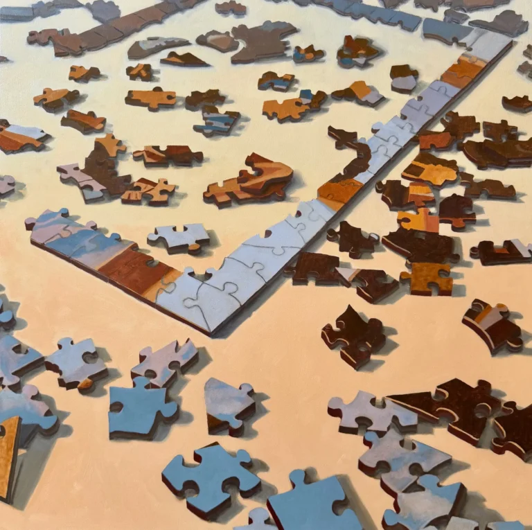 Loose puzzle pieces scattered on a beige surface with blue strips