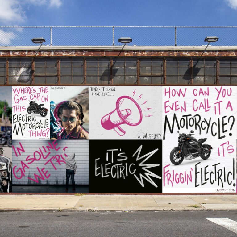 Long brick building with graffiti-filled mural panels and motorcycles on the wall.