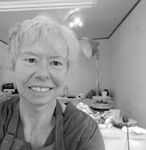 Smiling woman with short light hair in a room with gifts