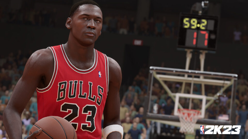 Basketball player dribbles ball wearing a red "Bulls 23" jersey. In the background, a scoreboard displays "59.2" and "17." Spectators fill the arena. Text: "2K23."