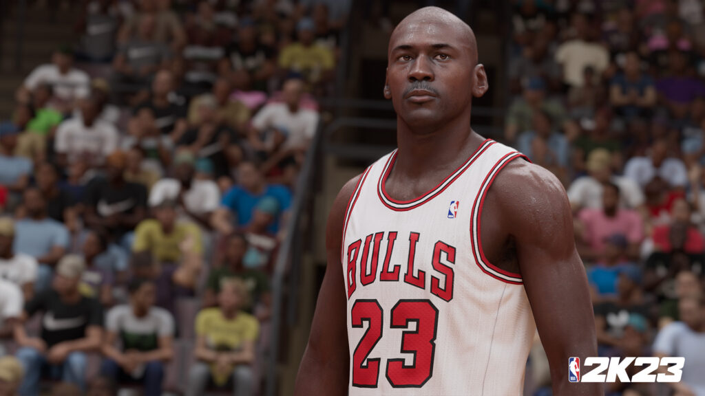 A basketball player in a "BULLS 23" jersey stands focused, with a crowded stadium audience blurred in the background. "NBA 2K23" is written in the bottom right corner.
