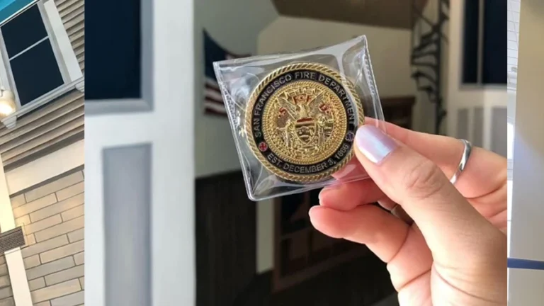 A hand holds a round, gold-colored emblem reading 