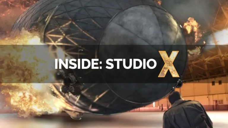 A large, spherical object explodes in a warehouse, with flames and debris surrounding it. Text reads 